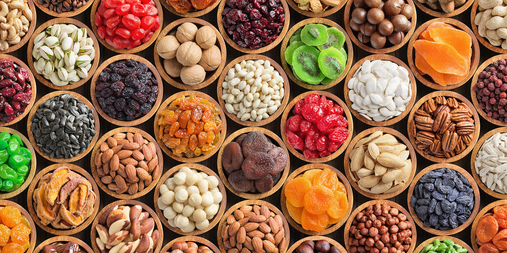 image of Assorted nuts and dried fruit background. organic food in wooden bowls, top view. 