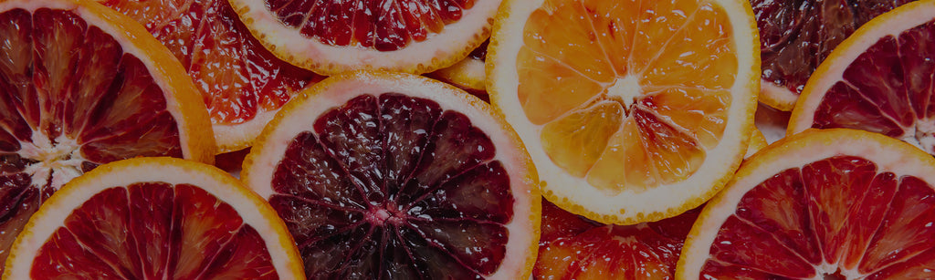 image of a close up shot of various citrus slices, mostly oranges, blood oranges, and cara cara oranges