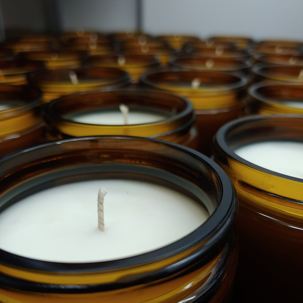 close up of amber jarred candles on a depth of field background