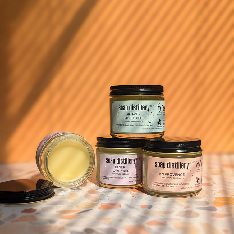 Three jars of multipurpose balms stacked against a tan background