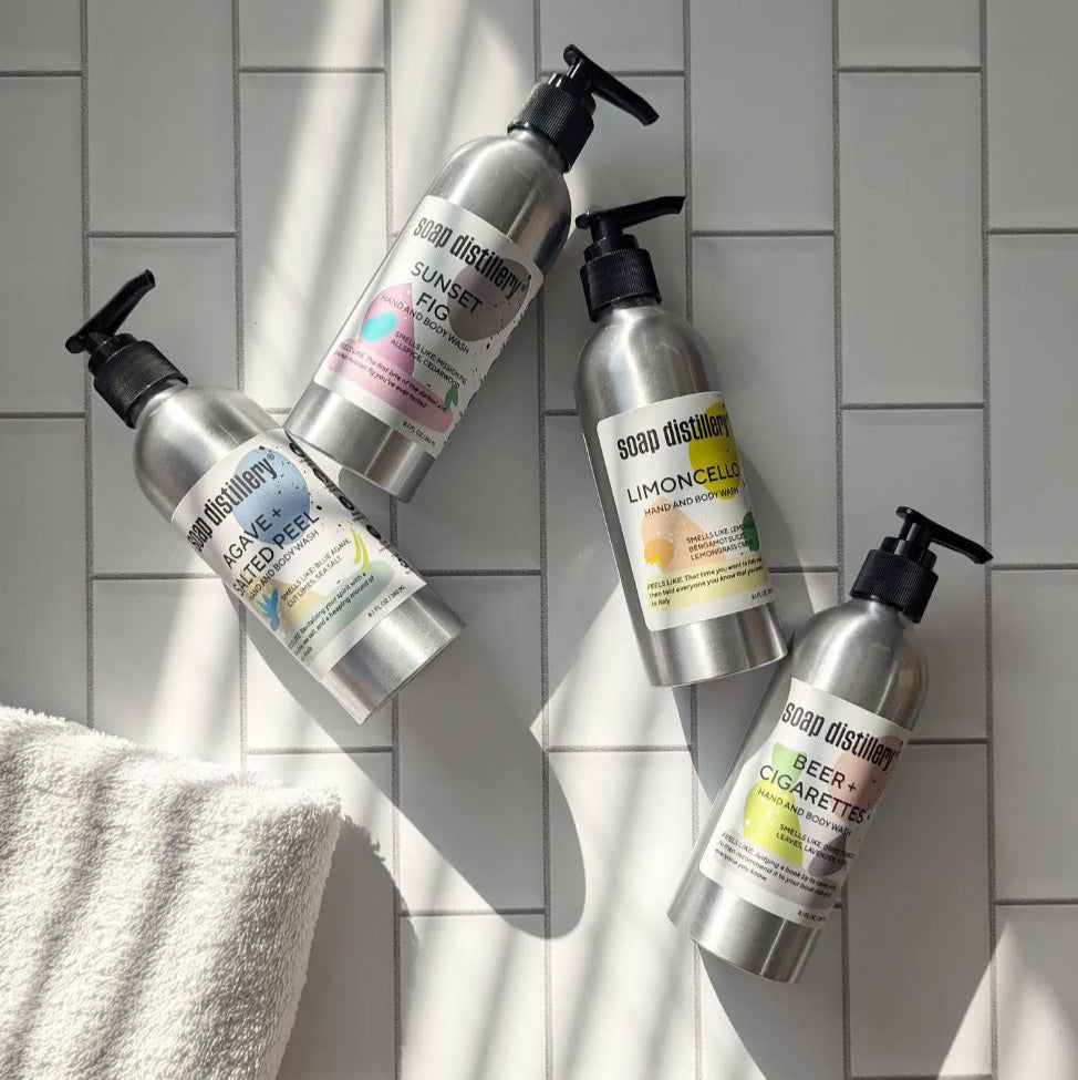 aerial shot of body washes in aluminum bottles on a white tiled sun bathed surfaced