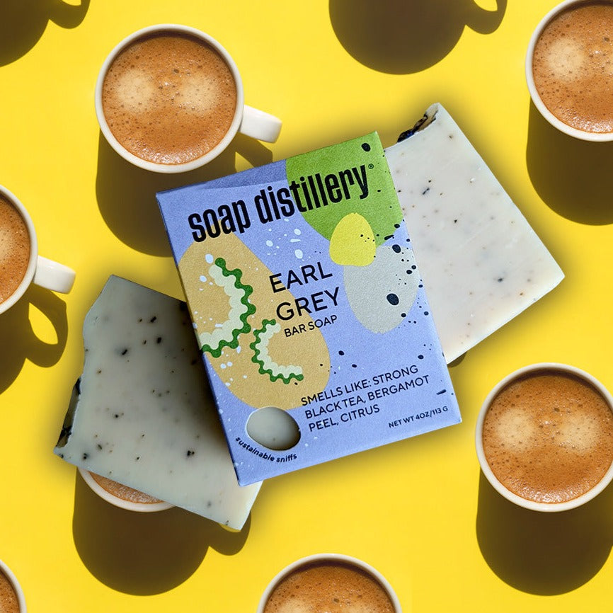 aerial view of earl grey bar soap in colorful packaging on a yellow background with a repeating pattern of tea cups