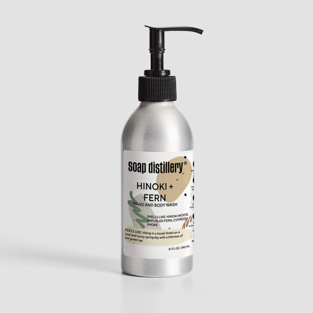 body wash in silver aluminum bottle with a white label with tan colors