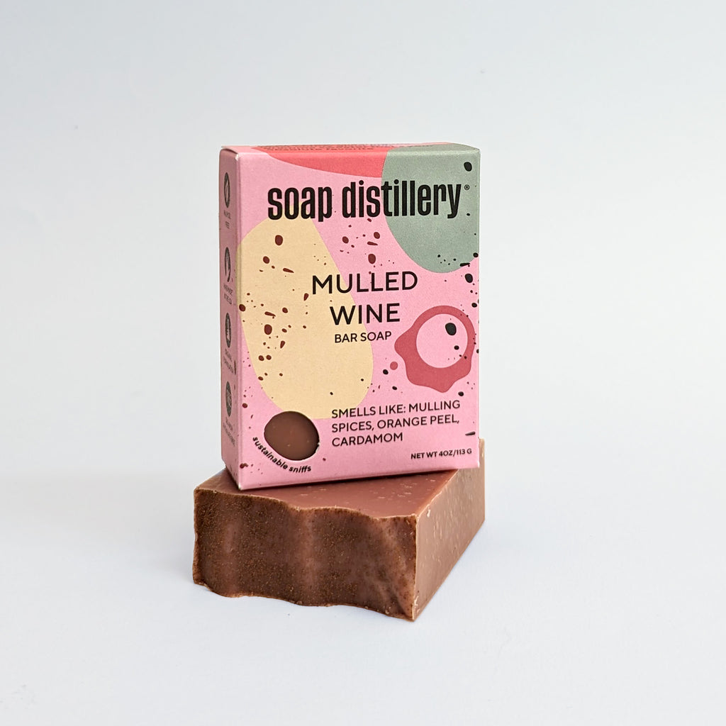 mulled wine bar soap on a light grey background in colorful pinkish packaging