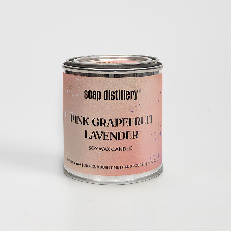 candle in a small paint can with a peachy pink colored label