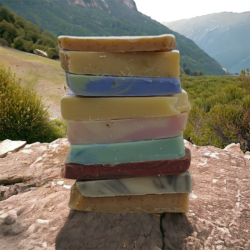 close up of a small stack of colorful soap pieces on a rock with mountains in the background