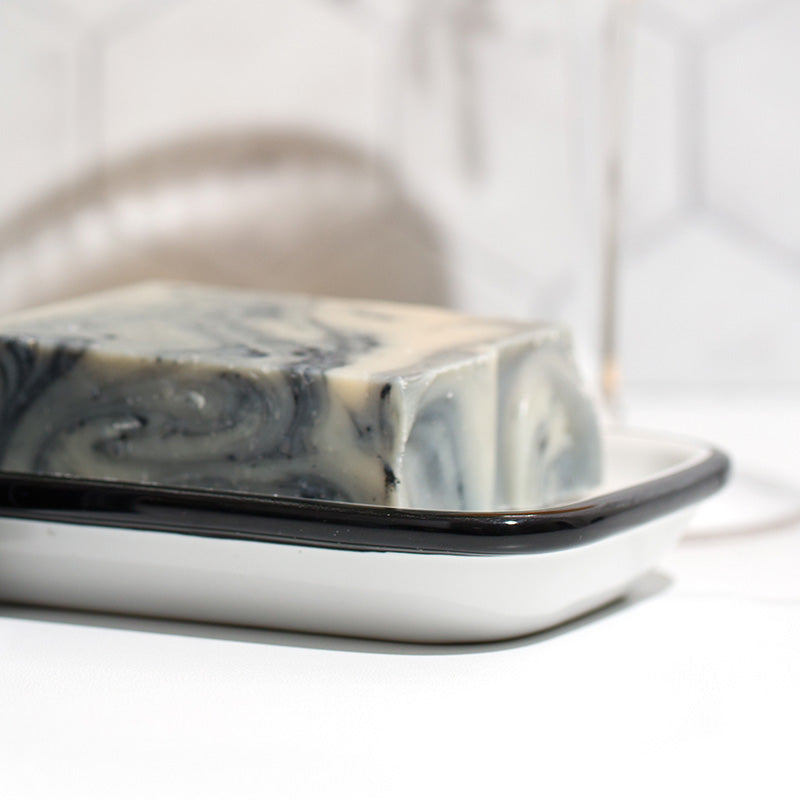 image of marbled soap sitting in a ceramic soap dish