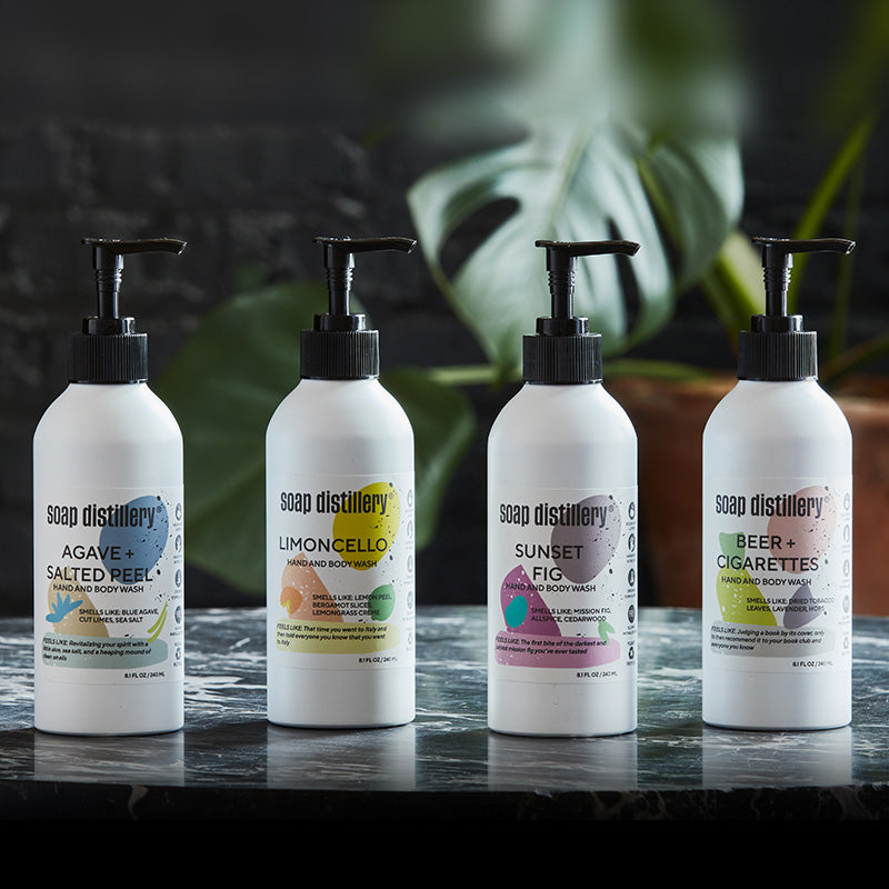 image of all body washes in white bottles with colorful labels in a lifestyle setting in a darker room